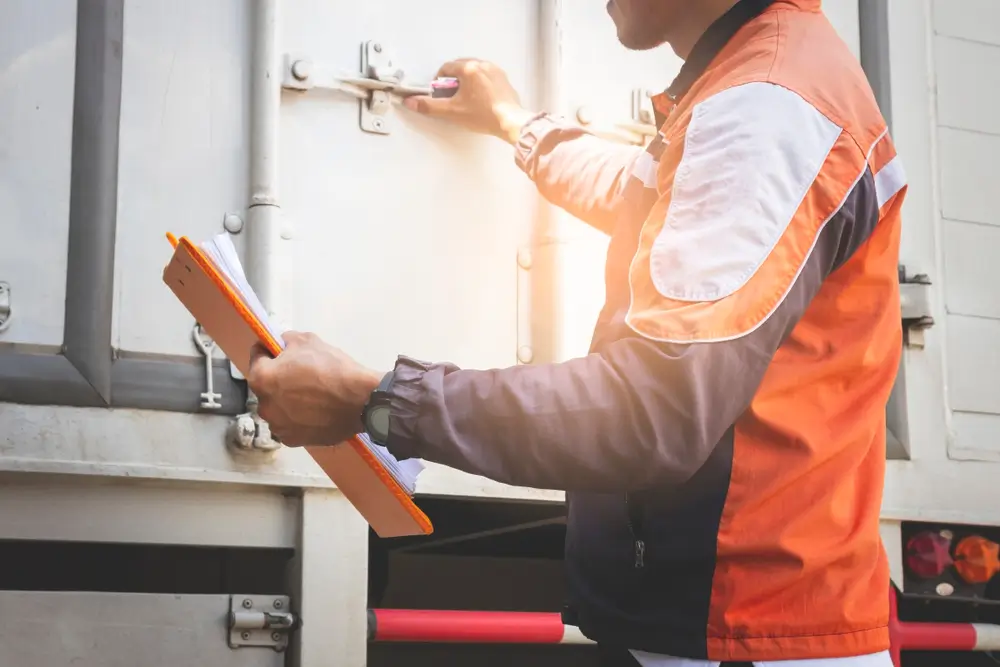 Agent des douanes inspectant le chargement d'un camion lors d'un contrôle à la frontière.