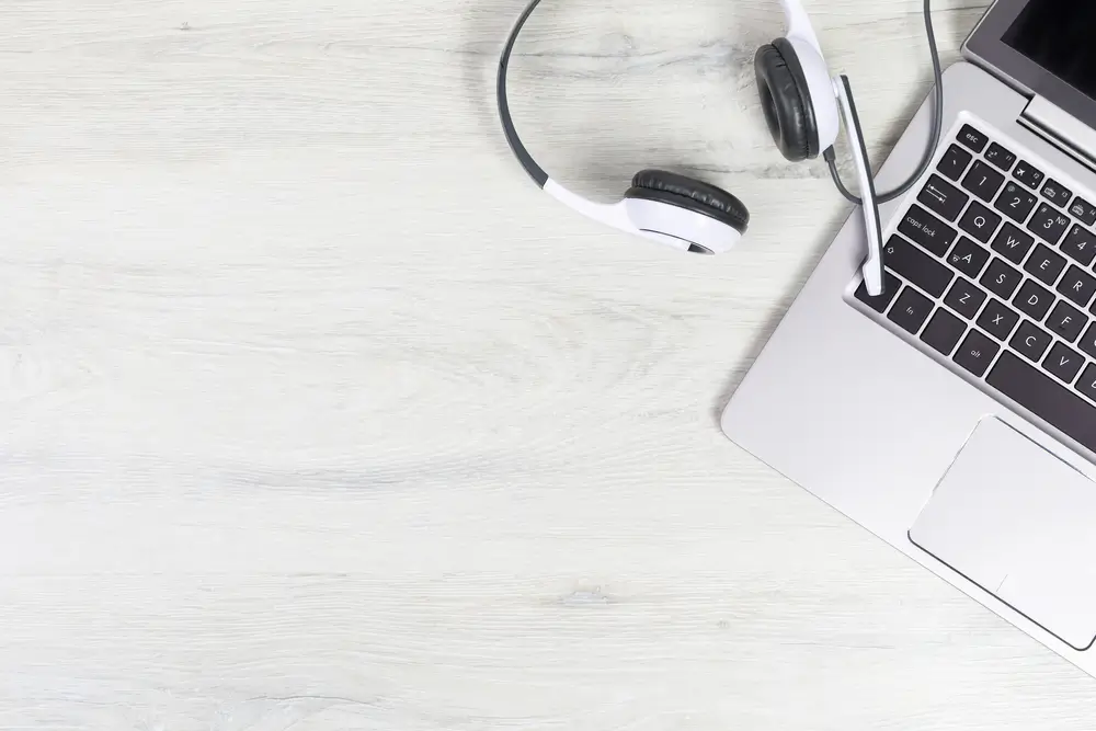 Casque avec microphone et clavier d'ordinateur portable posés sur un bureau pour un test de langue informatisé.
