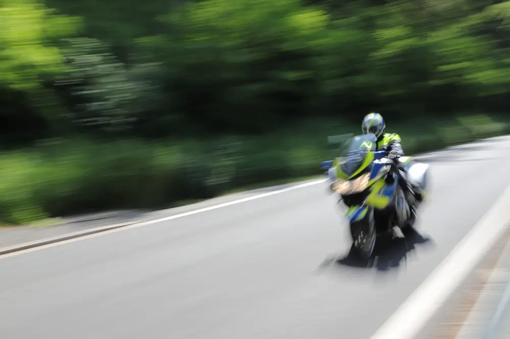 Moto de patrouille de la douane en mouvement sur une route pour une mission d'interception et de contrôle.