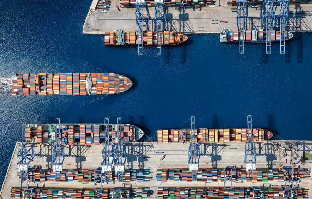 Vue aérienne d'un terminal portuaire international avec porte-conteneurs, lieu d'activité des agents des douanes.