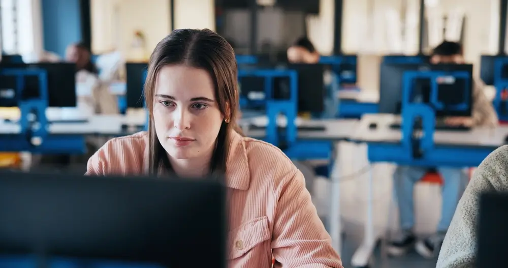 Candidate concentrée devant son ordinateur lors d'un test de sélection informatisé pour la fonction publique.