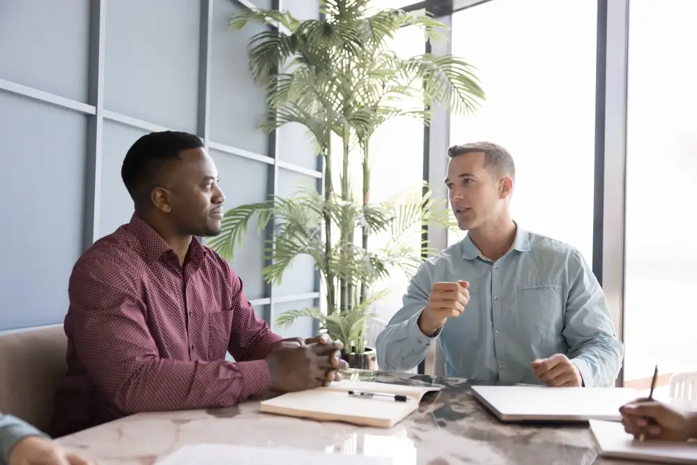 Candidat en discussion avec un jury lors d'un entretien d'embauche dans un bureau professionnel.